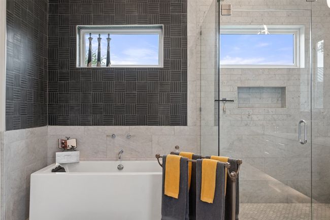 Designer tile and soaking tub create a sanctuary in the primary suite. | Image 21