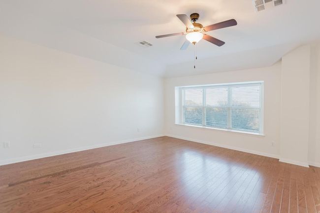 Primary Bedroom featuring visible vents, baseboards, wood finished floors, and a ceiling fan | Image 29