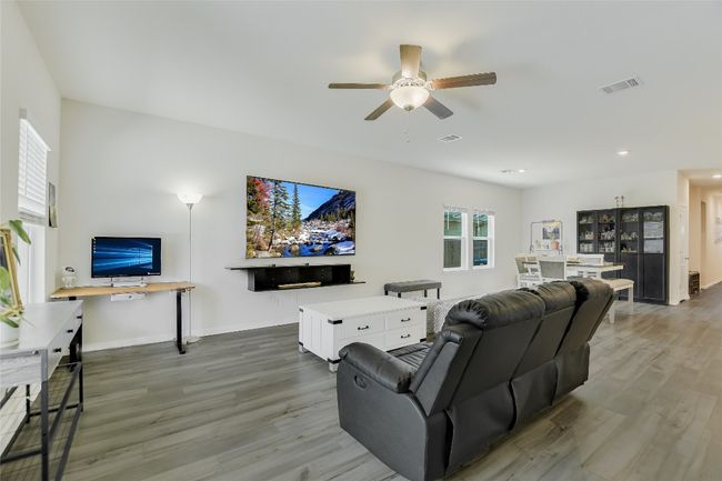 Living area featuring wood finished floors, a ceiling fan, recessed lighting, and baseboards | Image 14