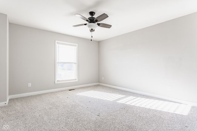 carpeted empty room with ceiling fan, baseboards, and visible vents | Image 34