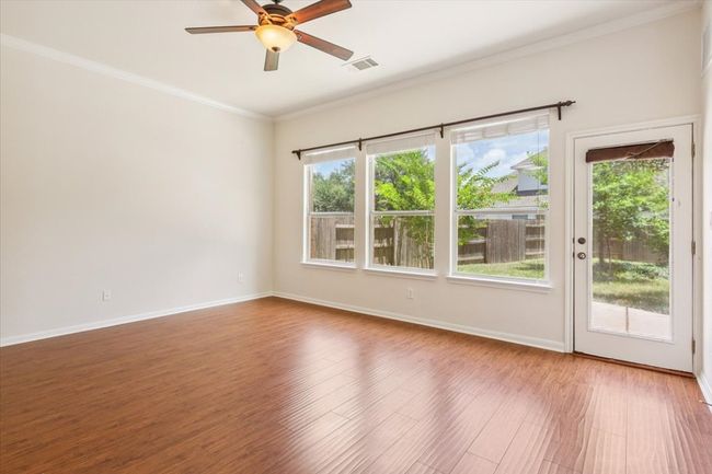 Empty room featuring plenty of natural light, a ceiling fan, wood finished floors, and crown molding | Image 26
