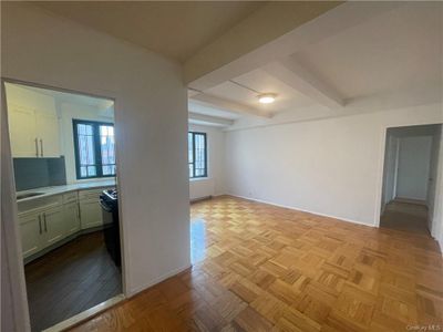 Unfurnished room with beamed ceiling, sink, and light parquet floors | Image 1