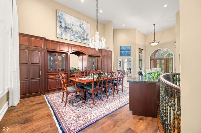 dining space with a towering ceiling, recessed lighting, a notable chandelier, and dark wood-type flooring | Image 16