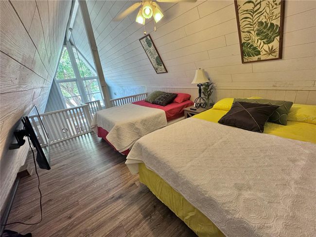 Spiral staircase to Loft bedroom with 2 beds and opens to outside balcony porch. | Image 28