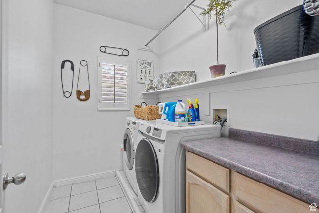 Clothes washing area with washing machine and clothes dryer, laundry area, baseboards, and light tile patterned floors | Image 23