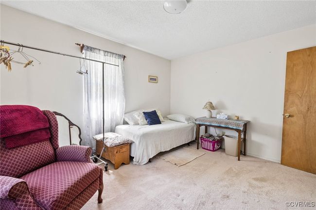 Carpeted bedroom with a textured ceiling | Image 17