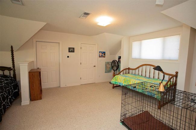 Bedroom featuring a water view, carpet, and vaulted ceiling | Image 35