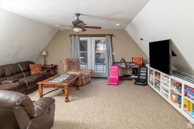 Living room featuring ceiling fan, lofted ceiling, carpet flooring, and a textured ceiling | Image 27