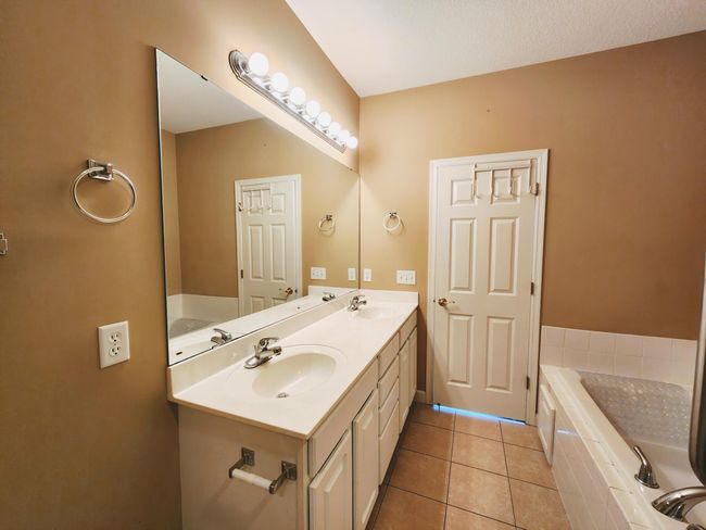 Ensuite with dual vanity, soaking tub, tiled shower & floors. | Image 11
