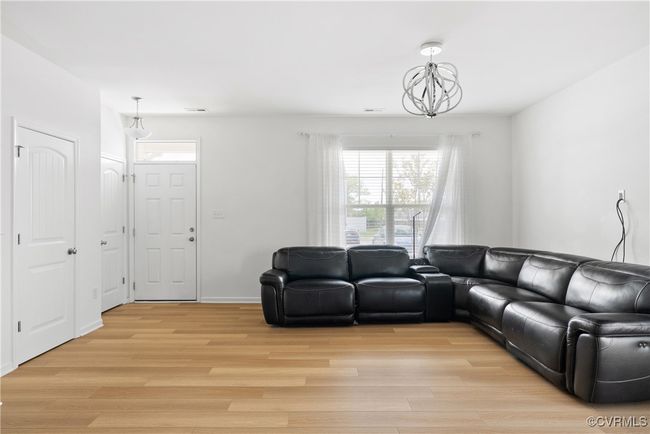 Living area featuring visible vents, a chandelier, plenty of natural light, and light wood finished floors | Image 8