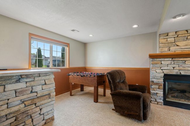 908 24th Ave NW - lower level family room contains a dry bar with attractive stacked rock facade to match the gas fireplace | Image 14