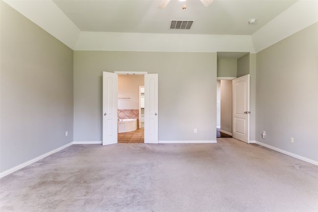 Unfurnished bedroom featuring carpet flooring, connected bathroom, high vaulted ceiling, and a ceiling fan | Image 10