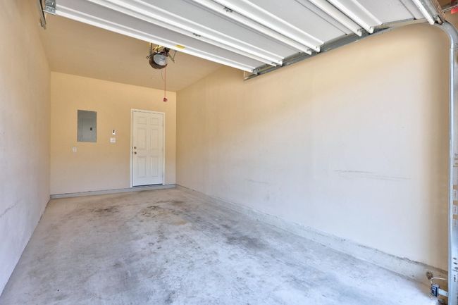 Garage featuring electric panel and a garage door opener | Image 29