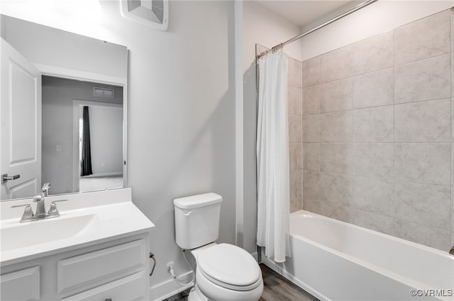 Full bath featuring vanity, shower / bath combo with shower curtain, and wood finished floors | Image 19