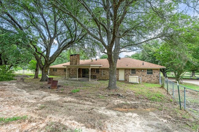 Back of house featuring a chimney, roof with shingles, and brick siding | Image 29