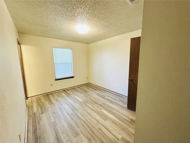 Unfurnished room featuring a textured ceiling and light wood-style floors | Image 27