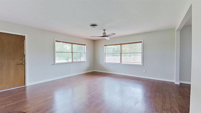 Unfurnished room featuring dark wood-style floors, baseboards, and ceiling fan | Image 5