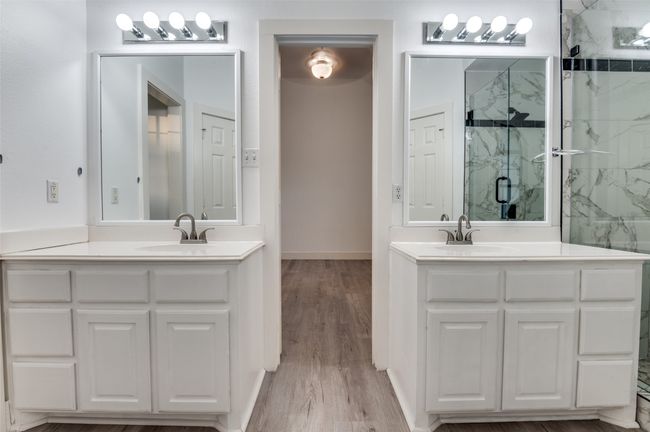Full bathroom with a marble finish shower, two vanities, and wood finished floors | Image 19