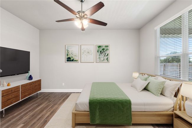 Bedroom featuring wood finished floors, a ceiling fan, and baseboards | Image 24