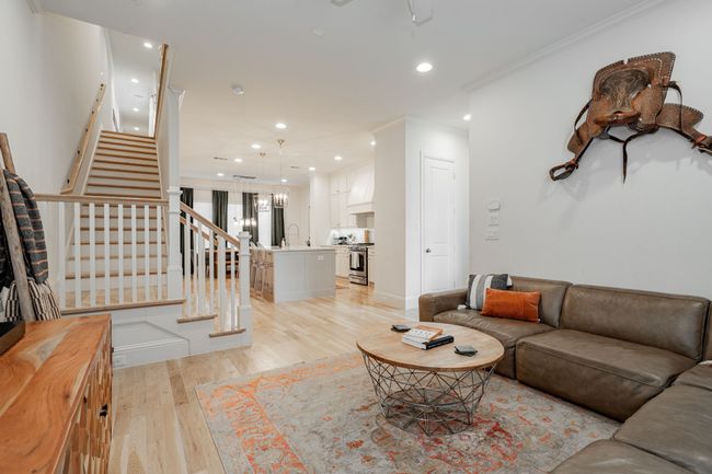 Living room fully furnished & decorated leading to the stairway to the three bedrooms. | Image 4