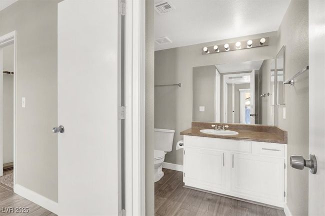 Bathroom with toilet, wood finished floors, visible vents, and baseboards | Image 21