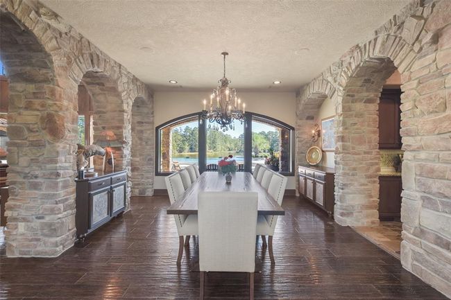 The spacious dining room offers views of the living room through stone peek-a-boo archways | Image 13