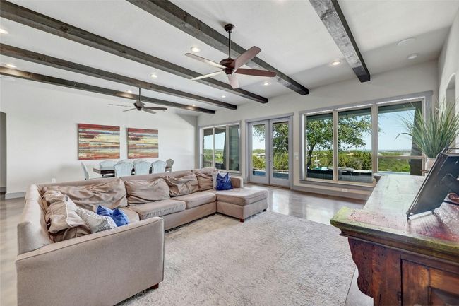 The square footage is in all the right places with this large family room! Wooden beams direct your eye toward a stunning hill country skyline. | Image 6