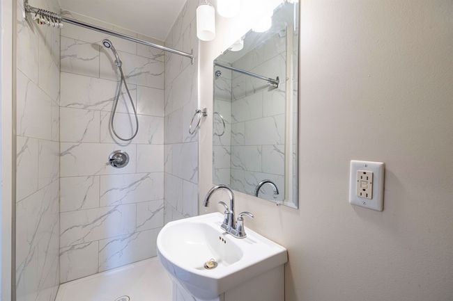 Full bath featuring a sink and a shower stall | Image 12