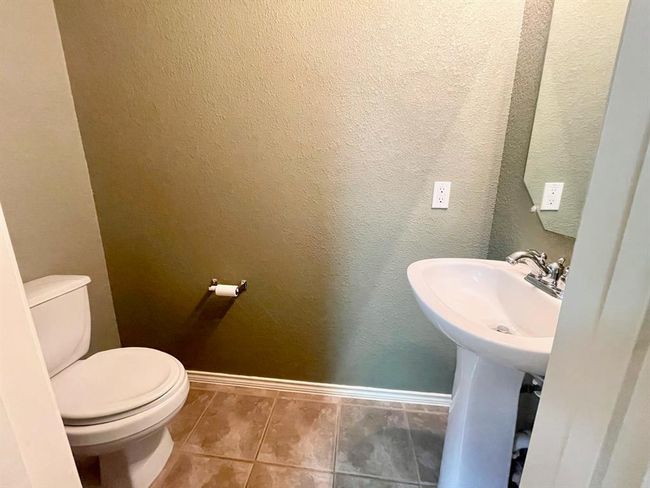 Half bath with toilet, tile patterned floors, and baseboards | Image 8