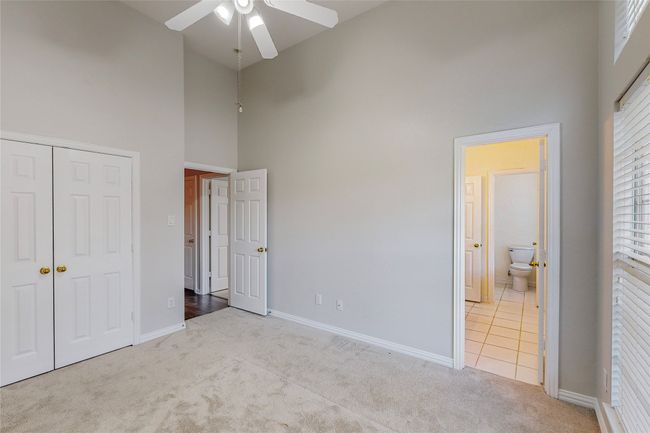 Unfurnished bedroom featuring a high ceiling, carpet flooring, baseboards, a closet, and a ceiling fan | Image 27