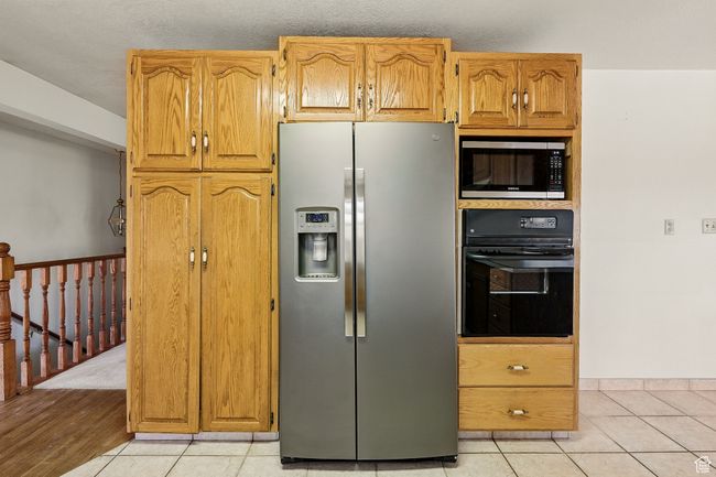 Kitchen featuring stainless steel appliances and light tile patterned floors | Image 14