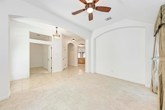 Spare room with vaulted ceiling, visible vents, ceiling fan, arched walkways, and carpet | Image 9