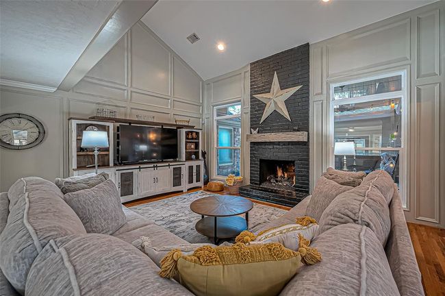 Spacious living room featuring a stylishly updated fireplace. | Image 10