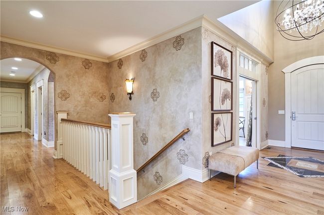 The foyer has a marble inlay design and volume ceilings .The foyer and hall has wide planked hickory floors and an open staircase that leads to over 3500 additional sq ft in the walk out basement. | Image 30