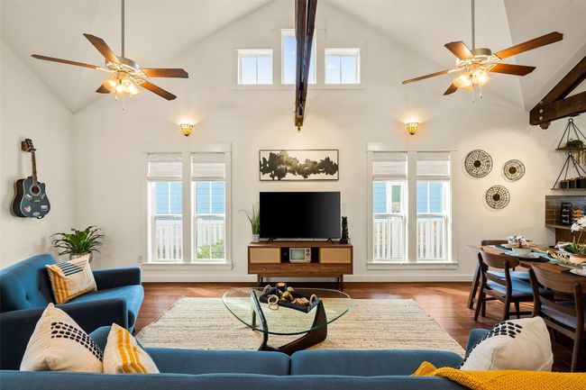 Living area with ceiling fan, high vaulted ceiling, plenty of natural light, and wood finished floors | Image 9