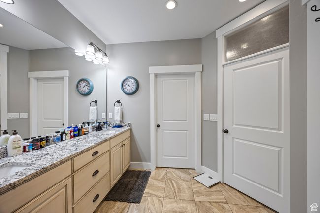 Bathroom featuring double vanity, baseboards, recessed lighting, and marble look tiles | Image 34