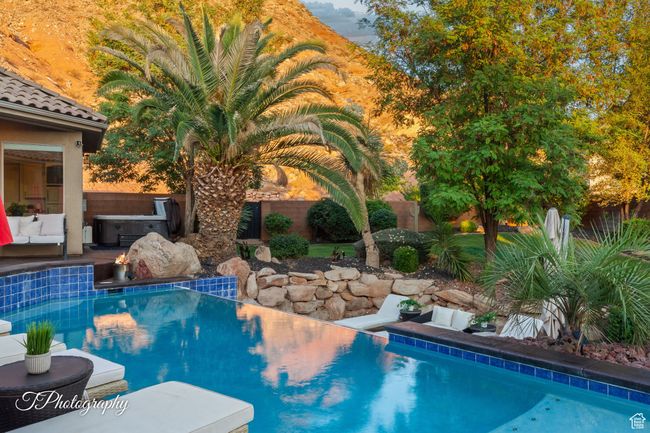View of swimming pool featuring a hot tub and a fenced backyard | Image 54