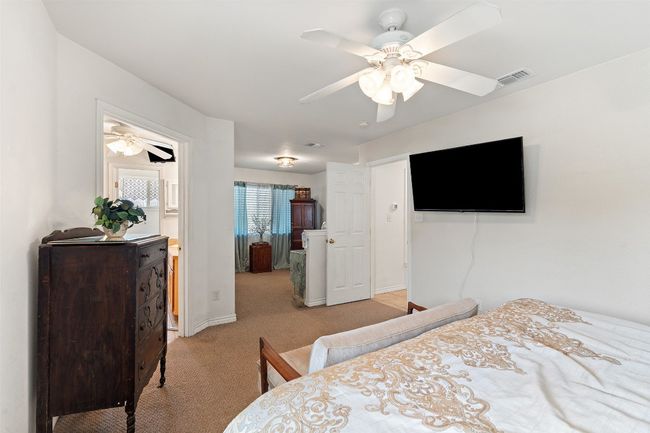 Bedroom featuring light carpet, baseboards, and ceiling fan | Image 26