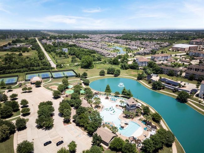 Enjoy resort-style living at Riverstone with this view of the sparkling pool, scenic lake, and top-notch tennis courts. Whether you're relaxing by the water, playing a match, or taking a dip, these amenities provide endless opportunities for recreation and relaxation. | Image 6