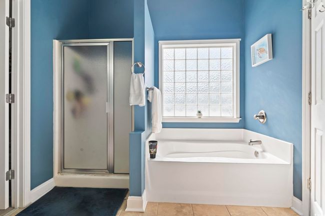 Full bathroom with a stall shower, a garden tub, and tile patterned floors | Image 20