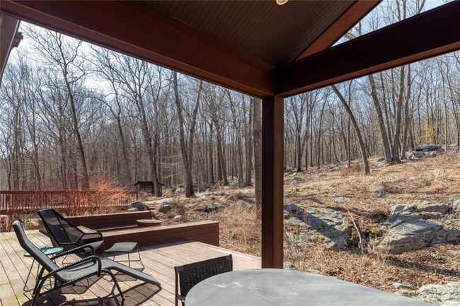 View of patio featuring outdoor dining area, a wooden deck, and a forest view | Image 31