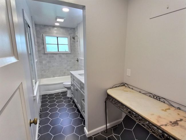 Bathroom with toilet, tub / shower combination, tile patterned flooring, vanity, and recessed lighting | Image 20