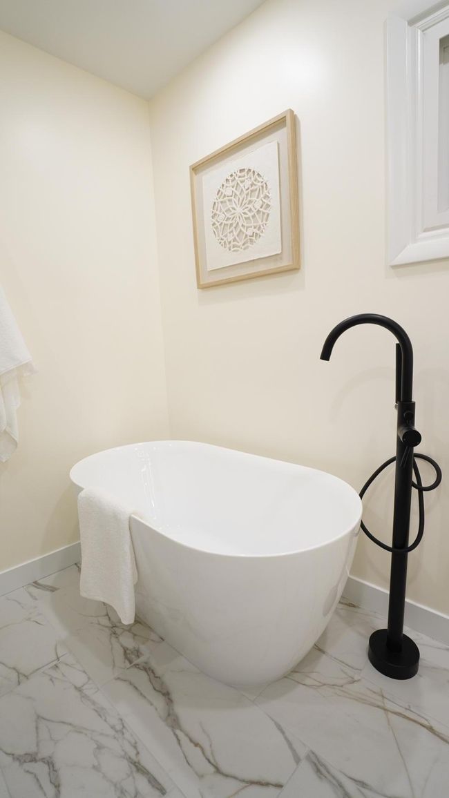 This freestanding tub was selected for its tall height and large capacity. Its elegant curved design and angled backrest lends itself to many a soothing bath. | Image 15