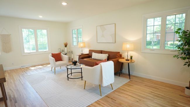 The view of this versatile and open living room from the front entry is warm and inviting. This home has very large side yards, allowing for an unusual amount of space between houses. With this brings some much desired light and privacy. | Image 42