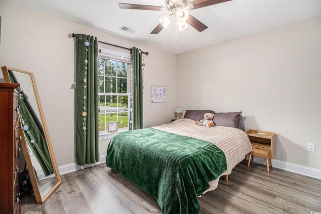 Bedroom with wood finished floors, baseboards, and ceiling fan | Image 15