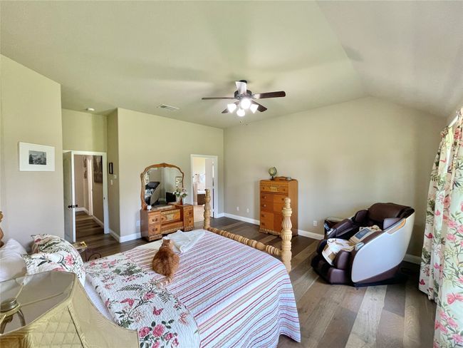 Bedroom with dark wood-type flooring, ceiling fan, baseboards, and lofted ceiling | Image 20