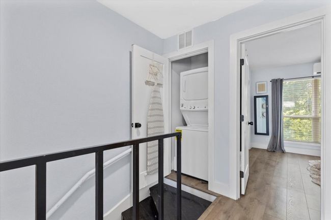 Corridor featuring stacked washer / dryer and wood finished floors | Image 19