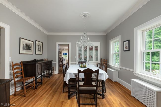 Dining area with an inviting chandelier, light wood-type flooring, ornamental molding, and radiator | Image 21