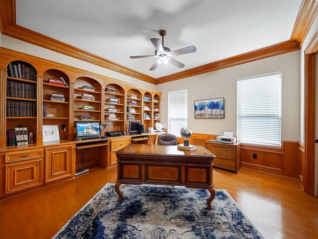 Spacious home office with elegant woodwork and ample natural light—ideal for productive remote work! | Image 12