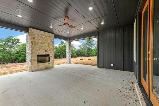 Wooden deck with an outdoor stone fireplace and ceiling fan | Image 32